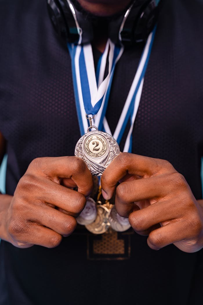 Home Close-up of hands holding a silver medal showcasing achievement and recognition.
